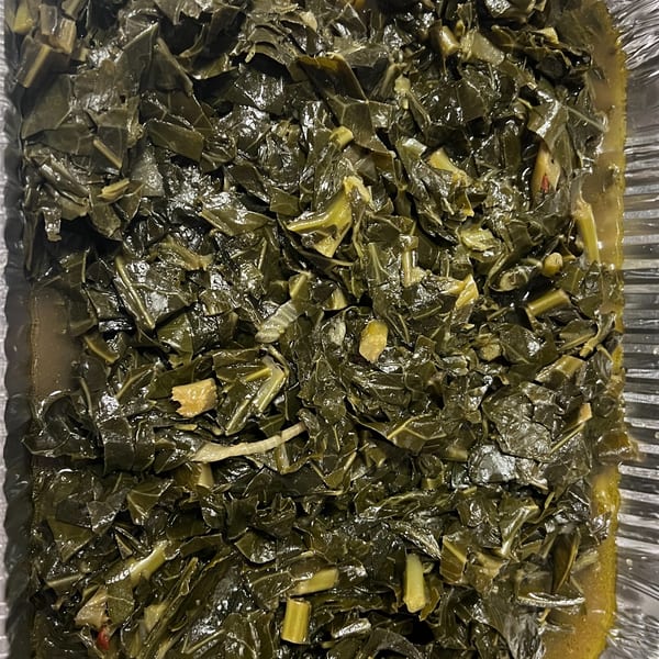 Close-up of C & E Southern Bites' collard greens, glistening in a foil pan.