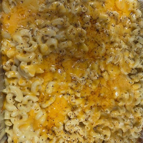 Close-up of baked macaroni and cheese from C & E Southern Bites, topped with black pepper.